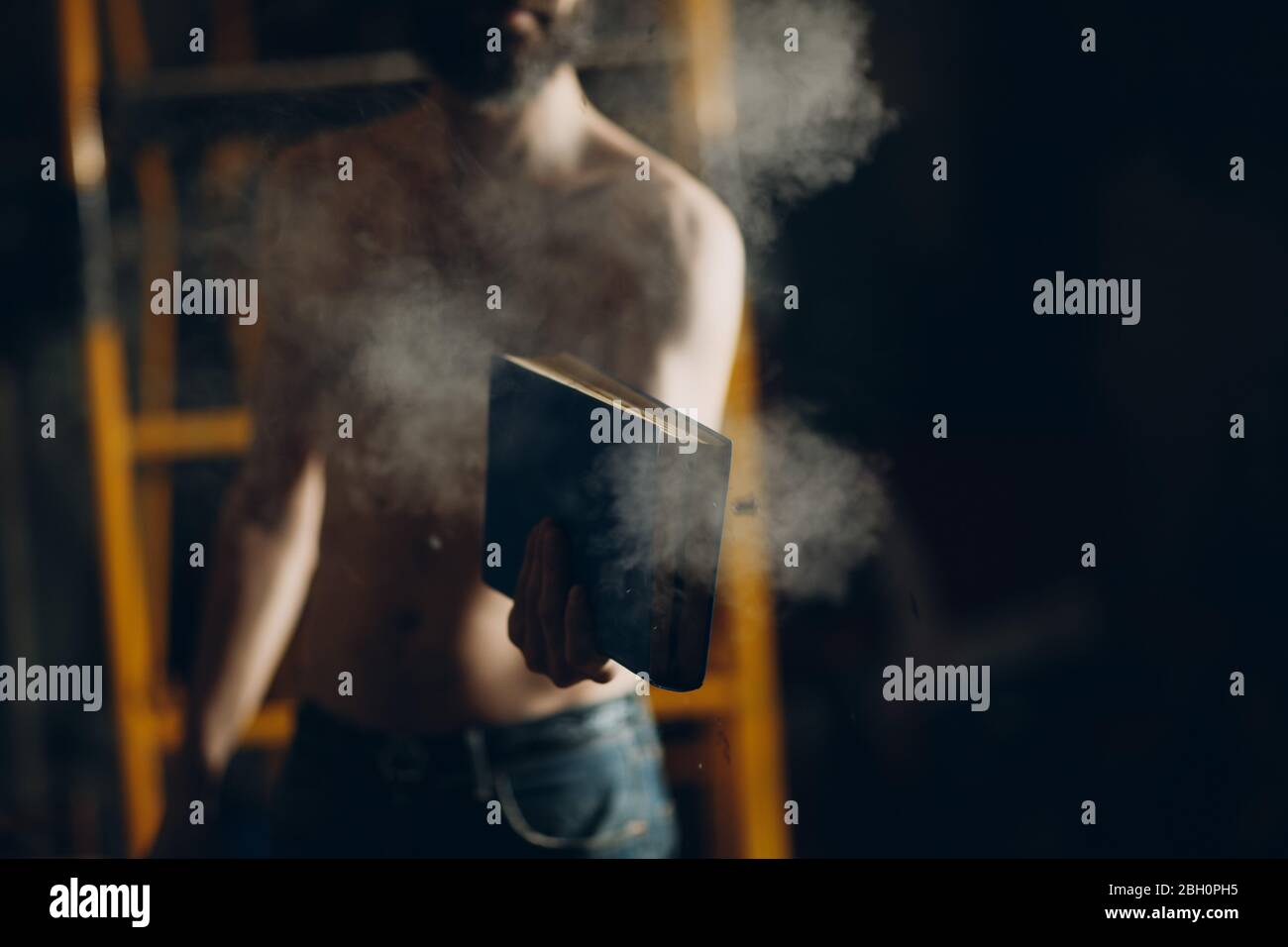 Man holds burning book in his hands. Stock Photo