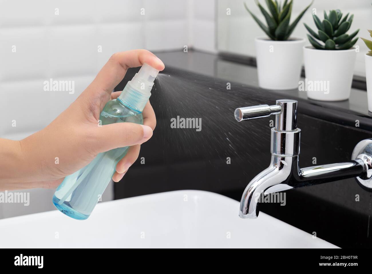 disinfect, sanitize, hygiene care. people using alcohol spray on faucet , hydrant and frequently touched area for cleaning and prevention of germs spr Stock Photo