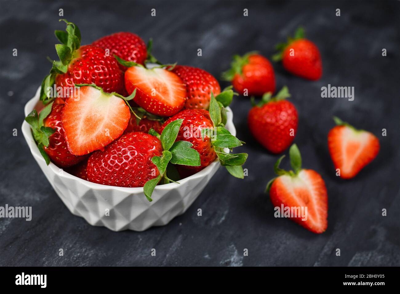Strawberries In A Bowl Showing Fresh Ripe Whole And Cut In Half Strawberry Fruits In A White Bowl On Dark Background Stock Photo Alamy