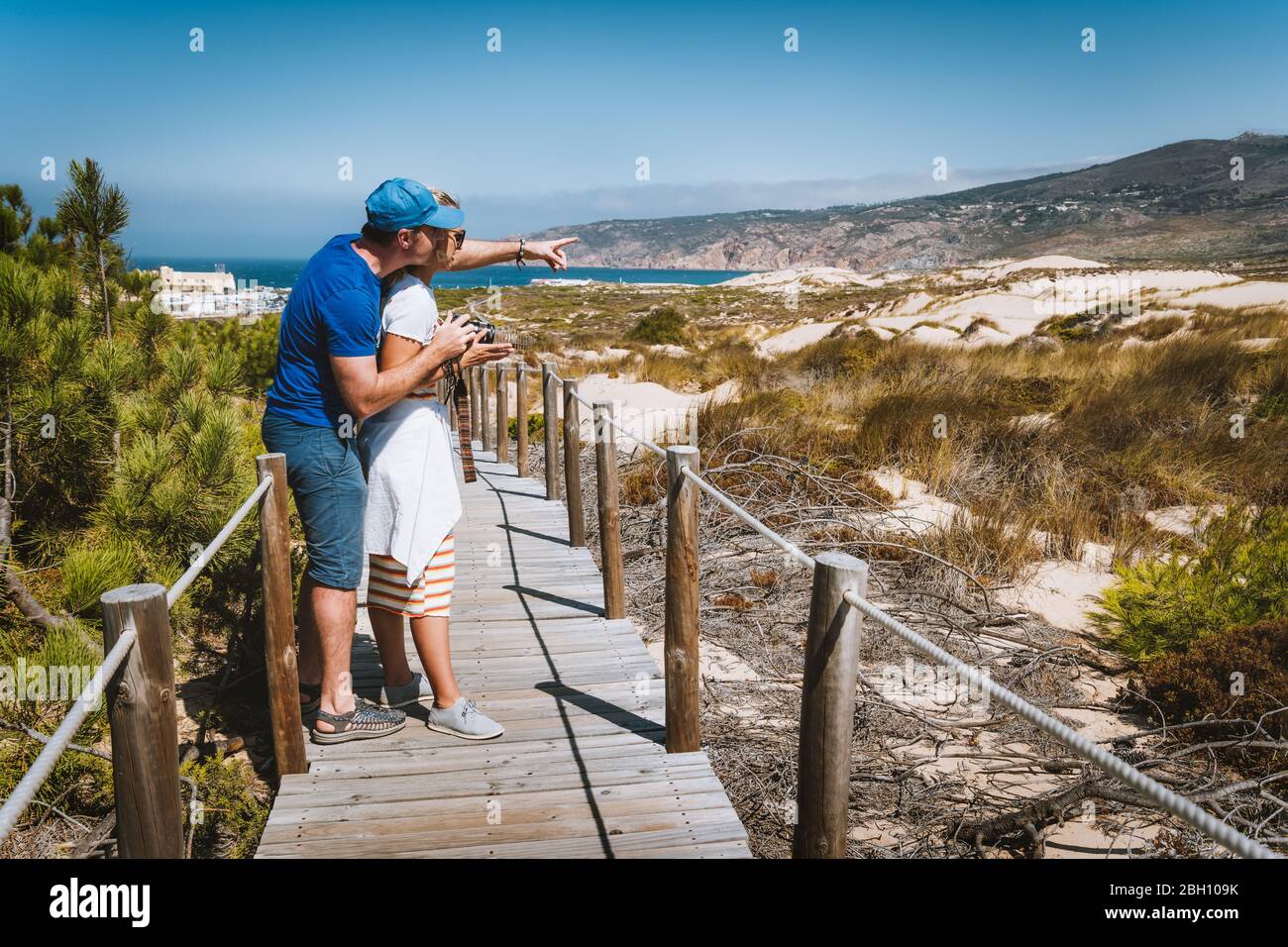 A Couple of tourist enjoying costal view of Praia do Guincho Beach. Cascais, Portugal Stock Photo