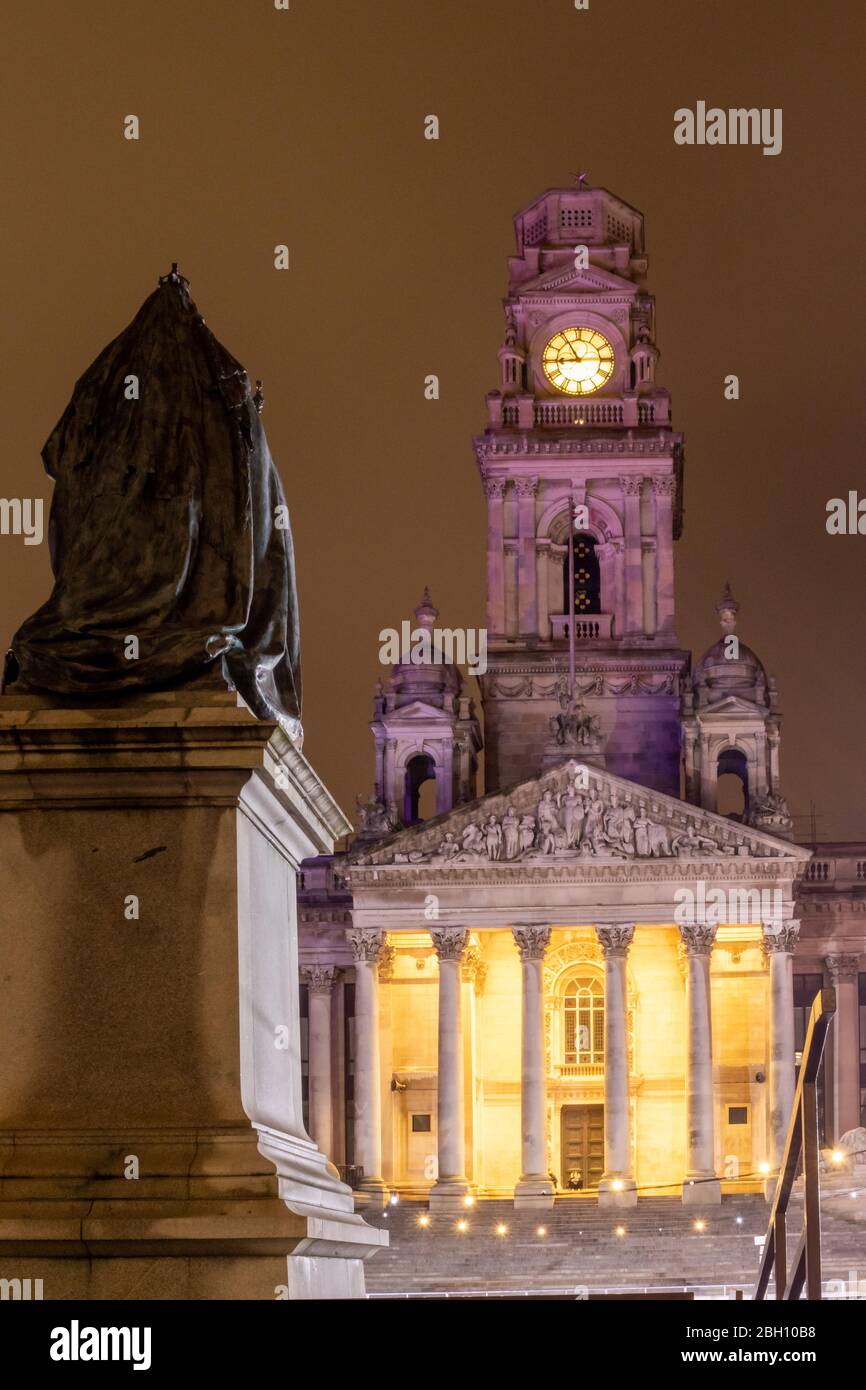 The exterior of Portsmouth Guildhall at night with the statue of Queen