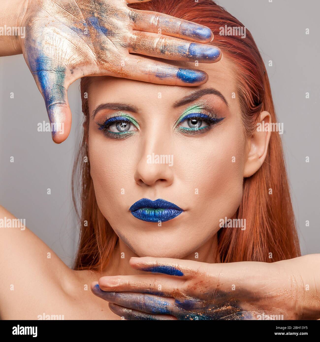 Beautiful fashionable ginger woman. Portrait of a fashion model with bright blue eye makeup. Stock Photo