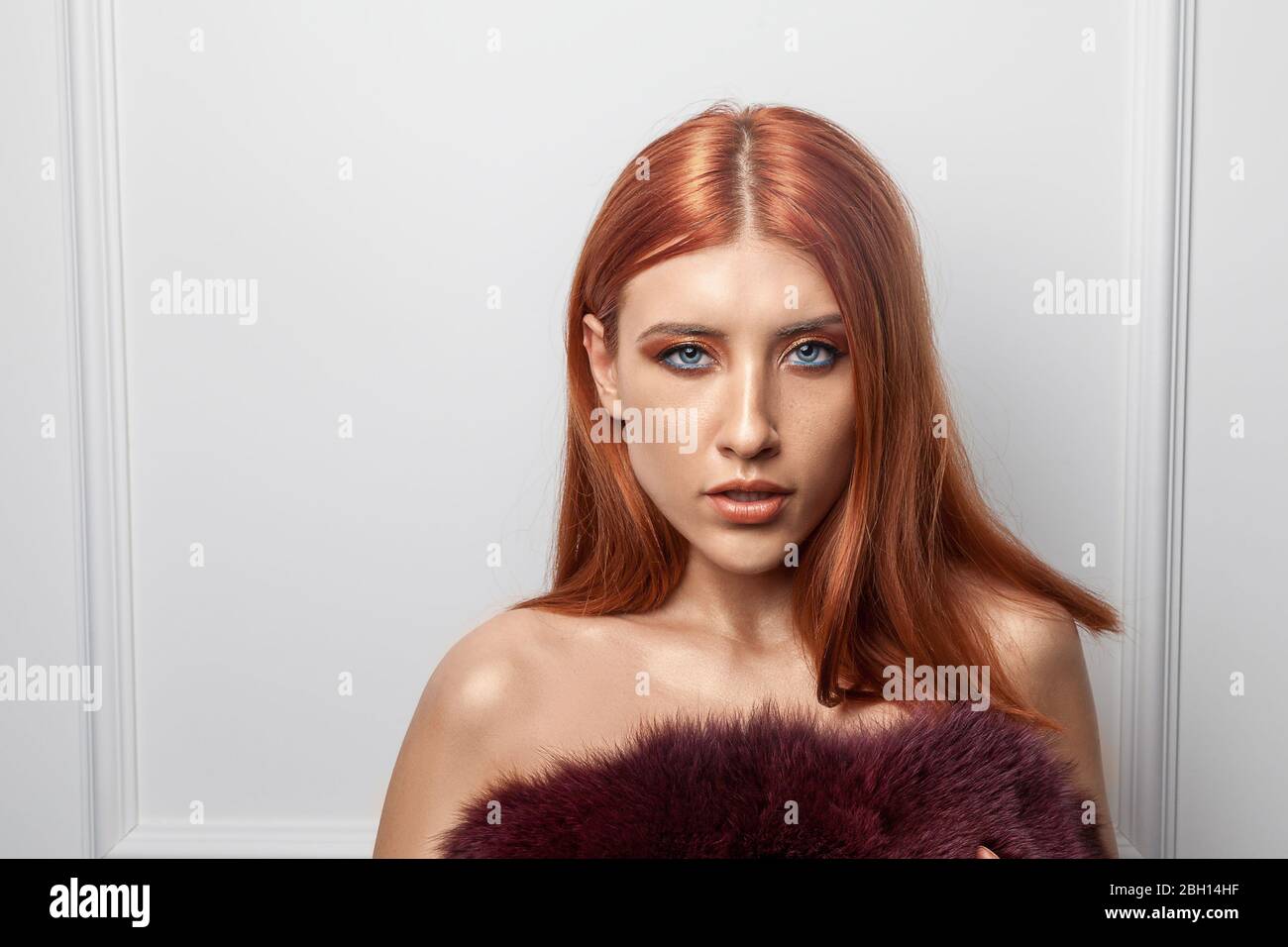 Beautiful fashionable ginger woman. Portrait of a fashion model with orange eye makeup. Stock Photo
