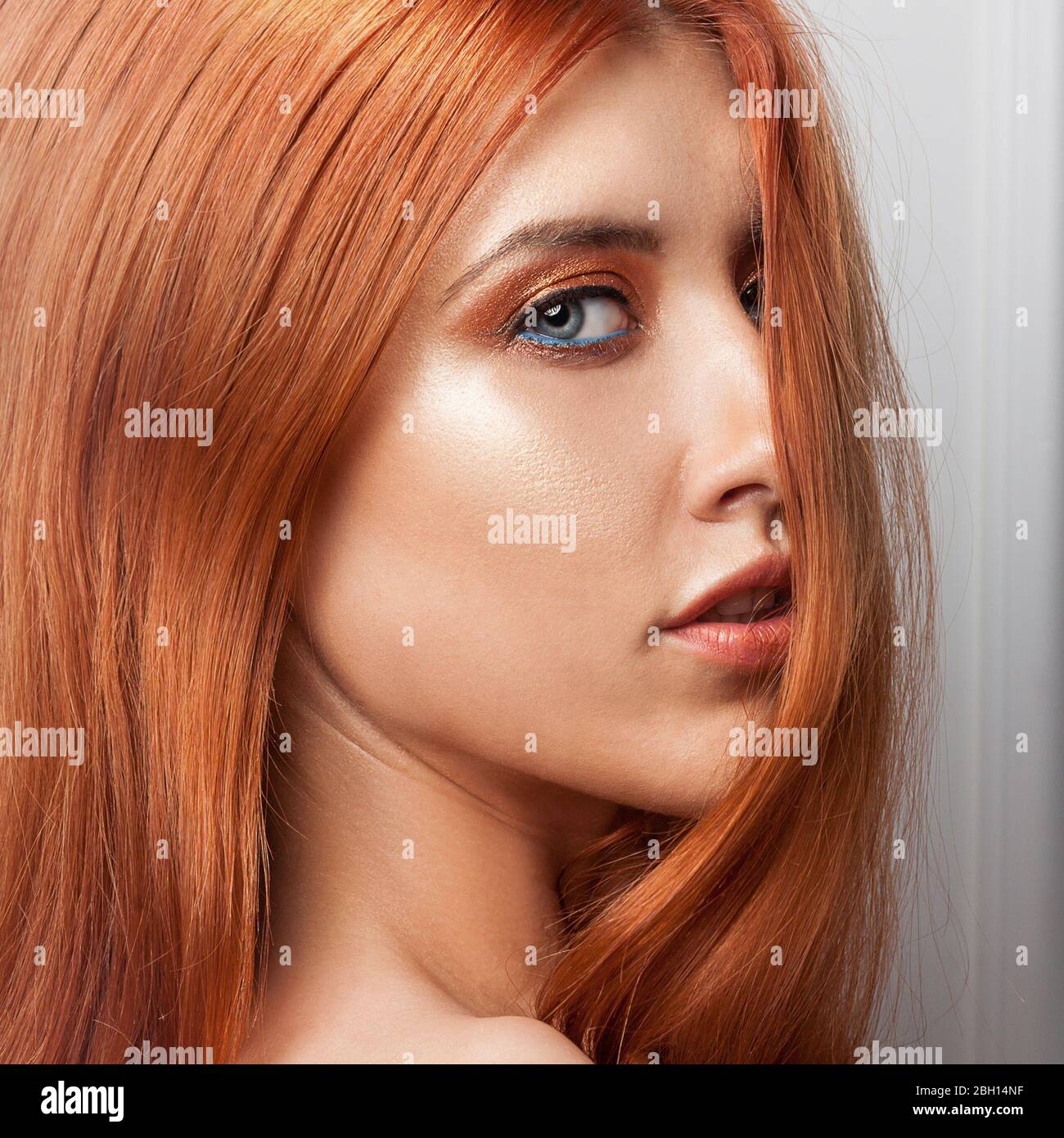Beautiful fashionable ginger woman. Portrait of a fashion model with orange eye makeup. Stock Photo