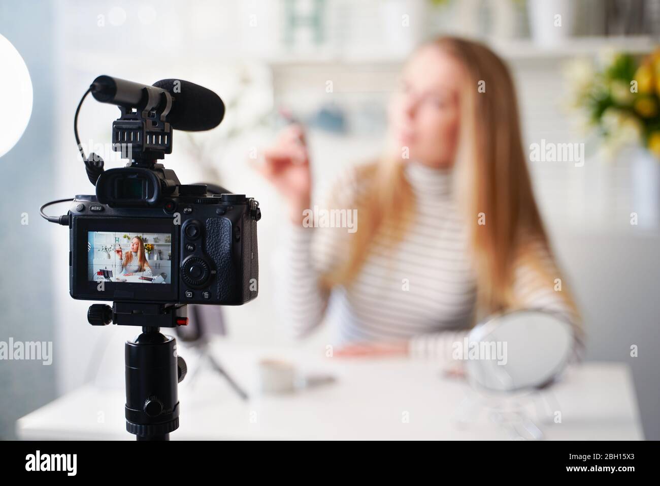 Display of camera recording video blog for blonde beauty blogger woman with make-up at home studio. Influencer vlogger girl live streaming cosmetics Stock Photo