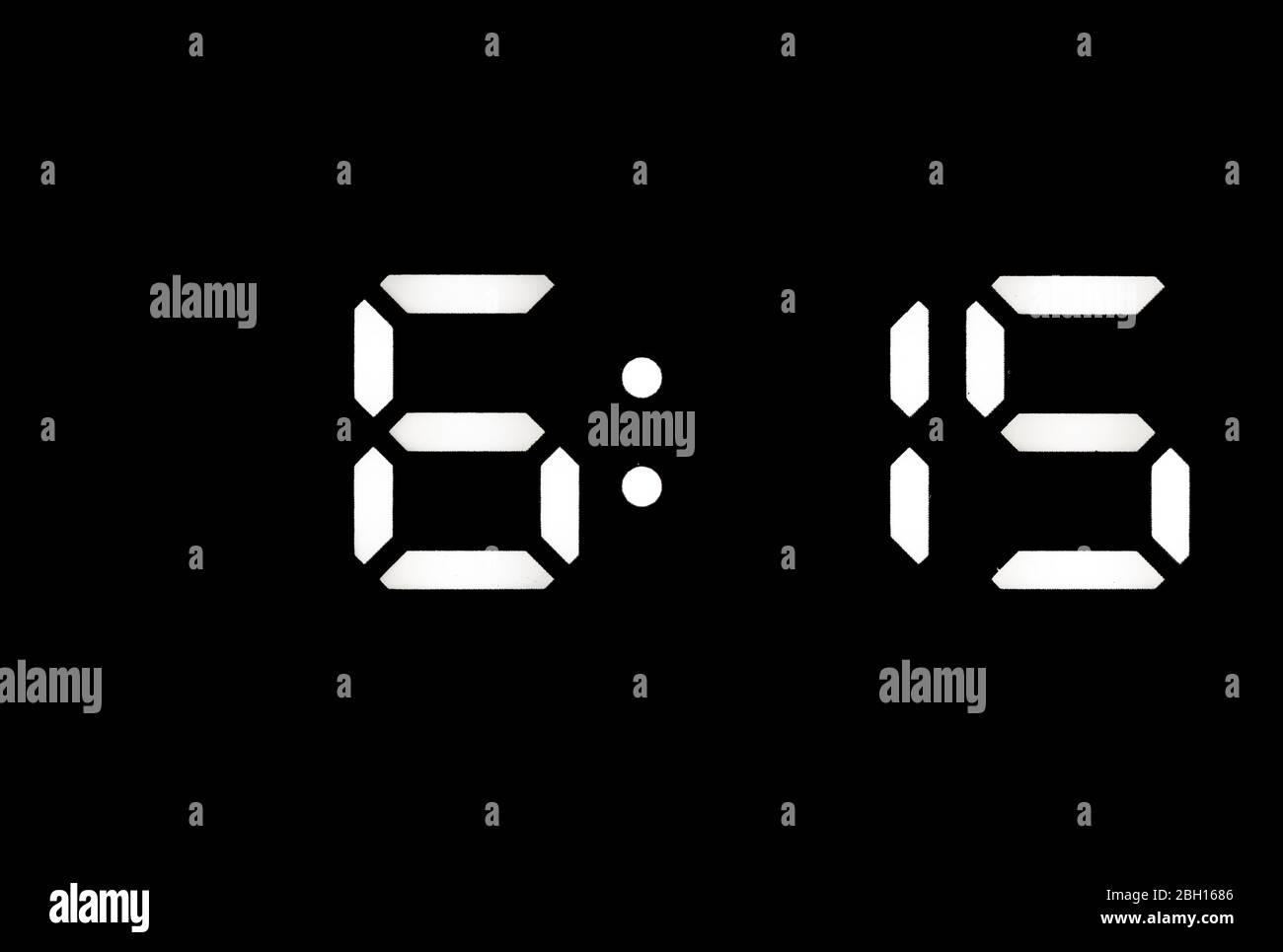 Real white led digital clock on a black background showing time 615