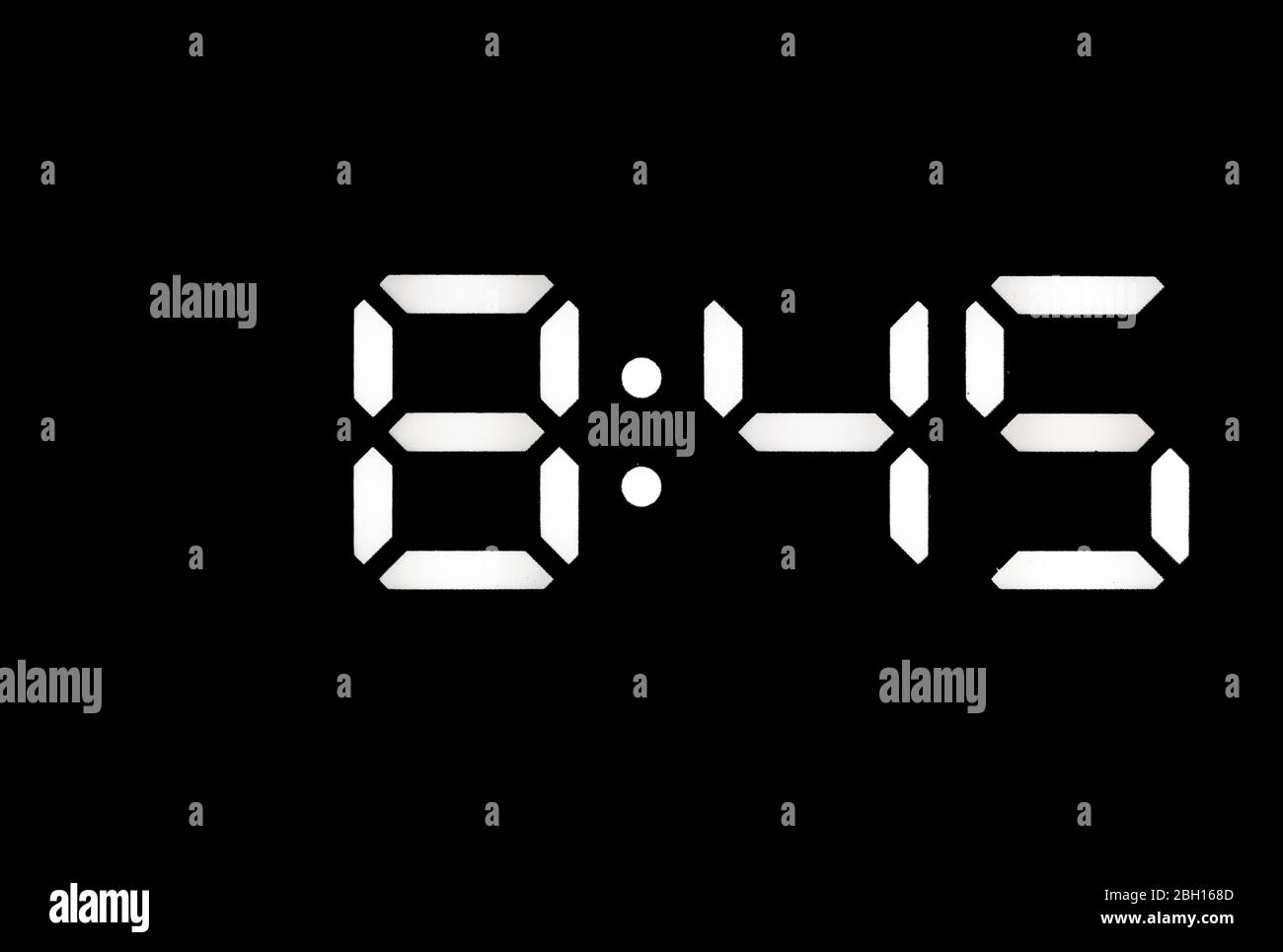 Real white led digital clock on a black background showing time 8:45 Stock Photo