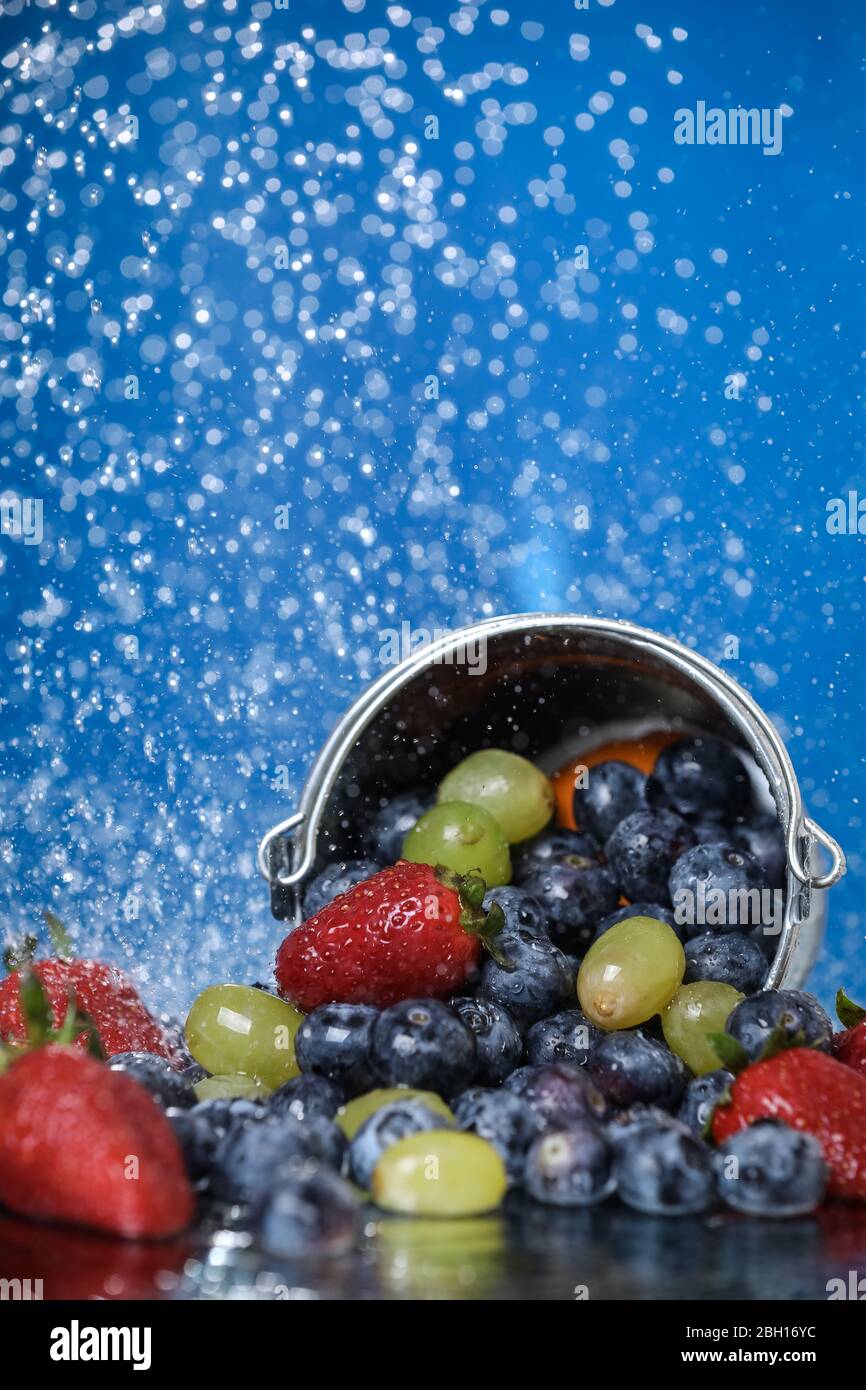 Fruit salad close up in falling metal bucket. Strawberry, grape ... Fruit salad close up in falling metal bucket. Strawberry, grape ...