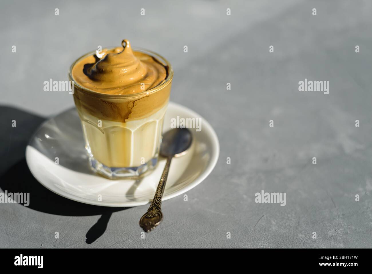 Dalgona instant coffee whipped drink in glass with plate and spoon