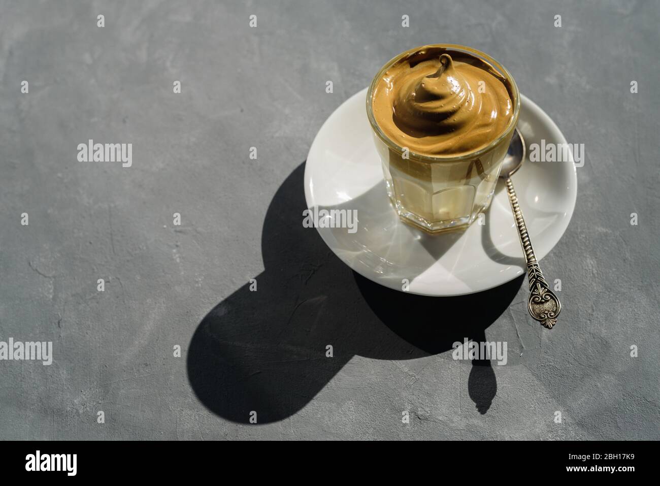 Dalgona instant coffee whipped drink in glass with plate and spoon