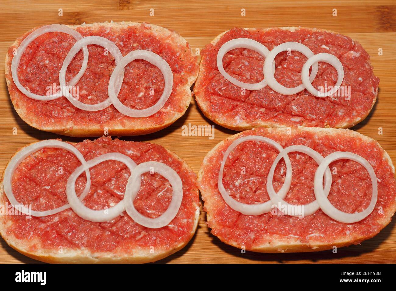 four half Mett on bread rolls with onion rings on a plate, Germany Stock Photo