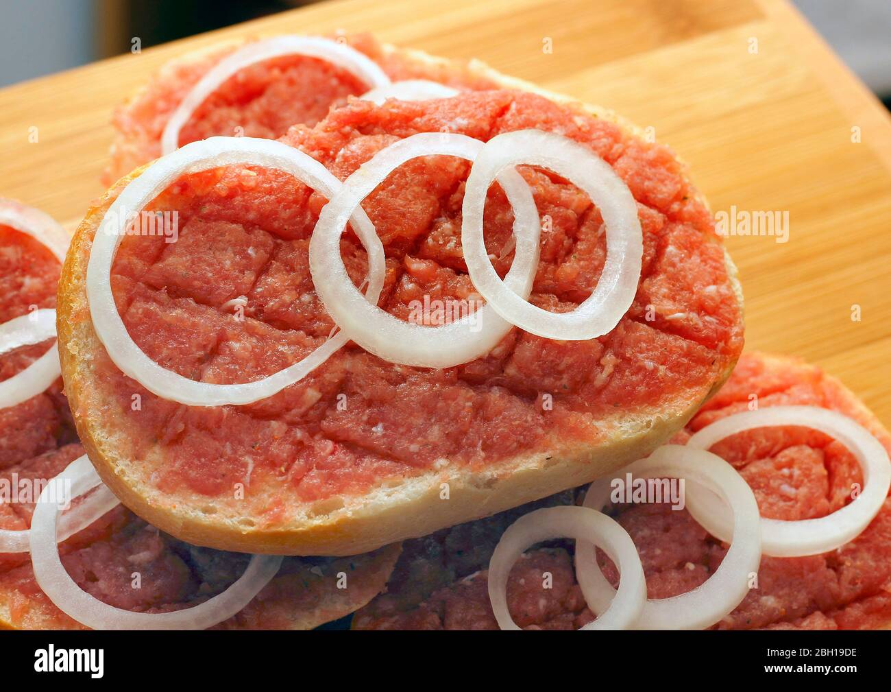half Mett on bread rolls with onion rings on a plate, Germany Stock Photo