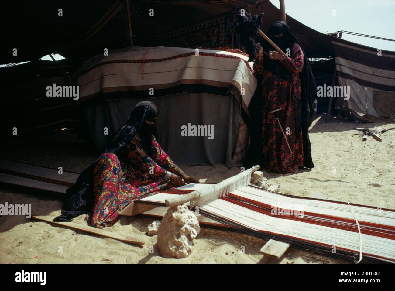 Qatar, Bedouin women weaving and spinning outside tent. Stock Photo