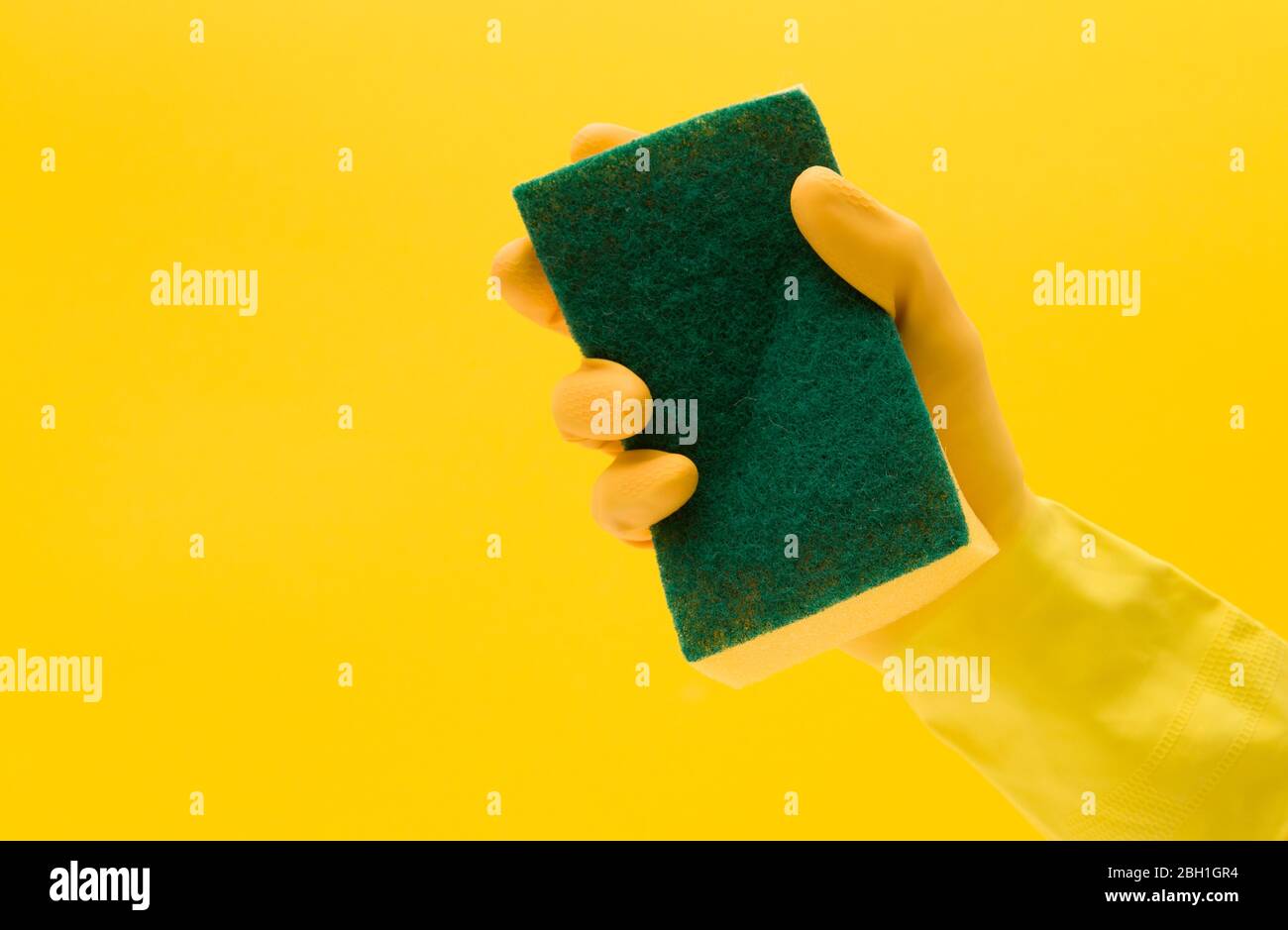 Hand wearing a yellow rubber glove holding a cleaning sponge Stock ...