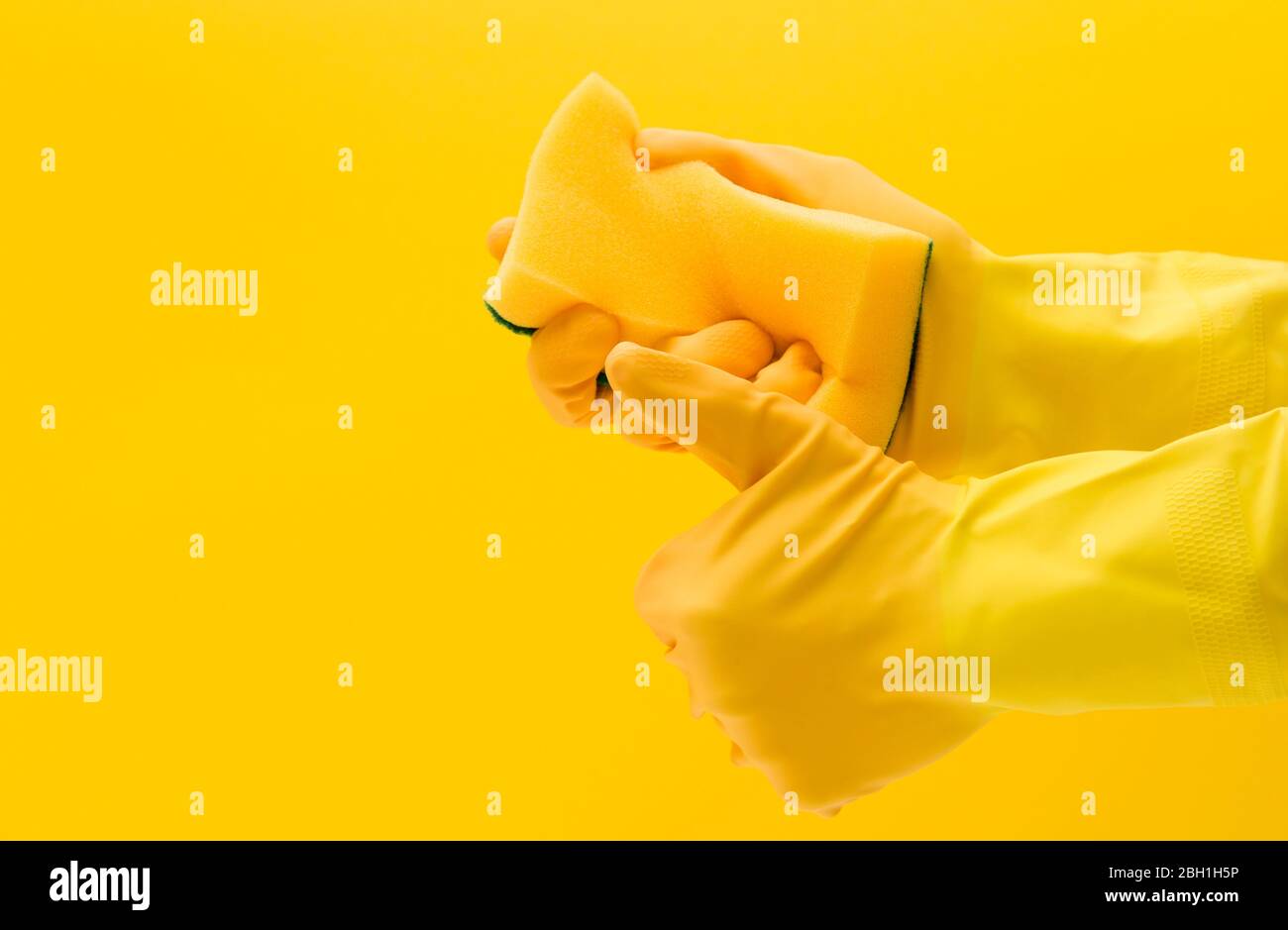 Hand wearing a yellow rubber glove holding a cleaning sponge Stock ...