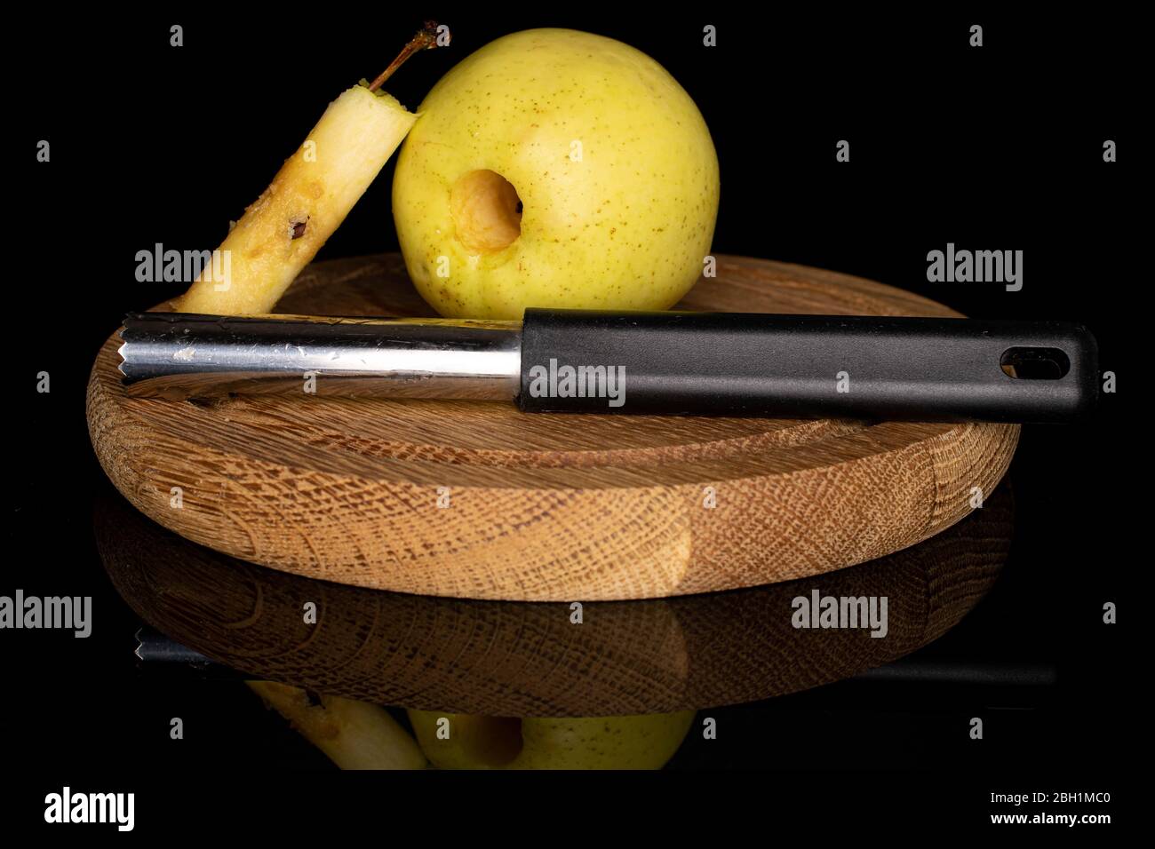 Group Of One Whole One Piece Of Green Delicious Apple With Core Seed Remover Isolated On Black Glass Stock Photo Alamy