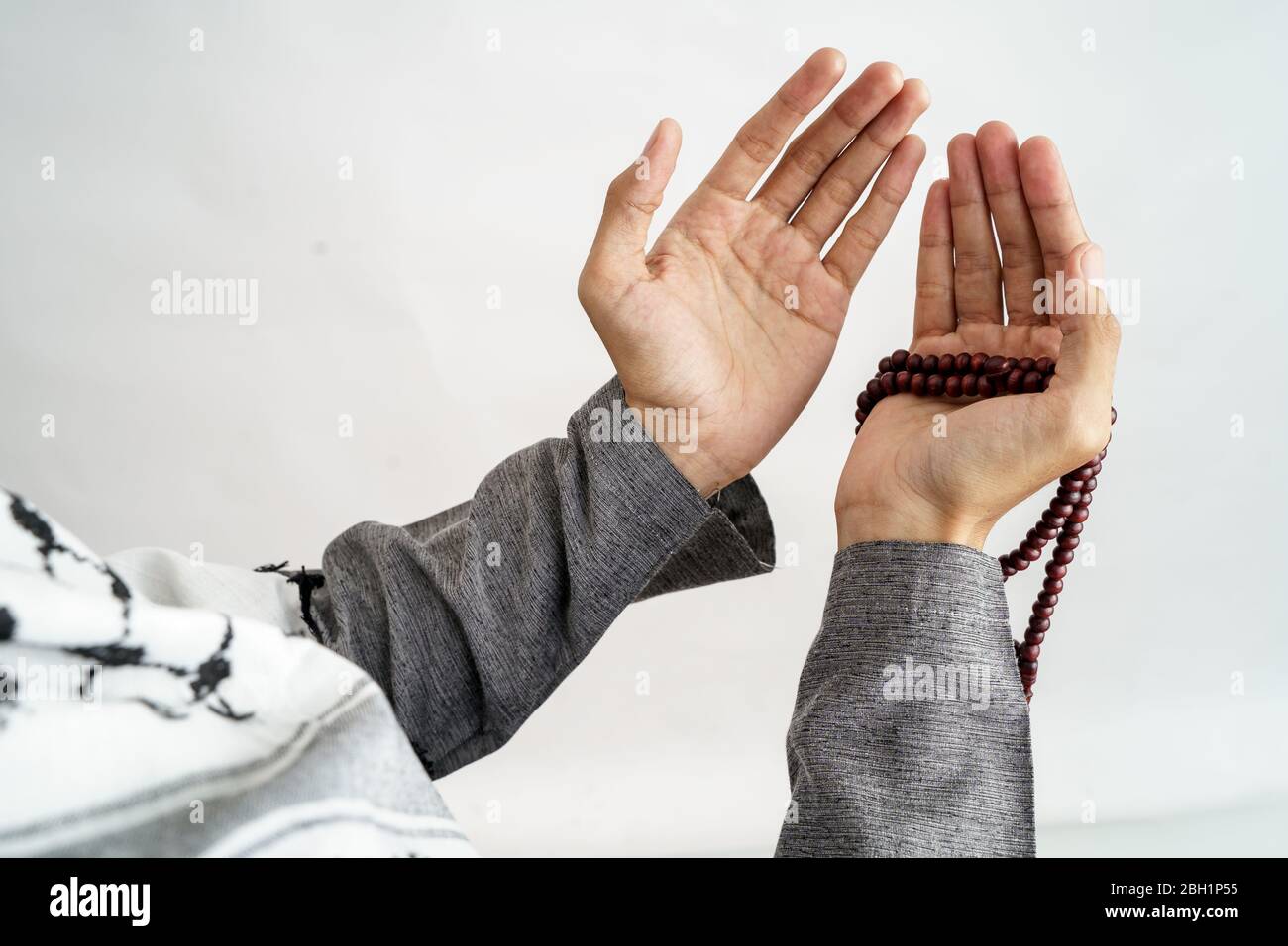 gesture of hand open arm while pray in islamic culture carrying prayer  beads over white background Stock Photo - Alamy