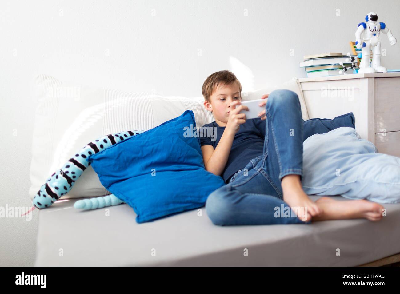 Boy playing with his smartphone during the corona crisis Stock Photo