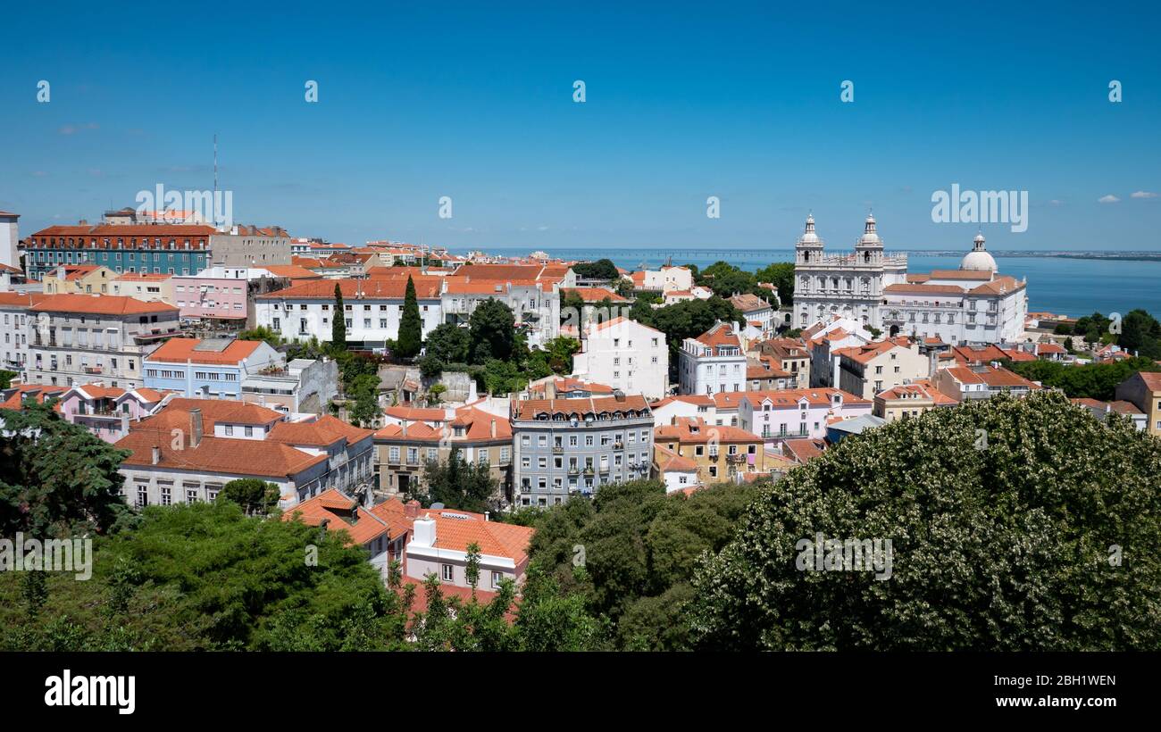 Old Lisbon. A panoramic view over the rooftops of the Old Town of the Portuguese capital of Lisbon on a bright and sunny summers day. Stock Photo