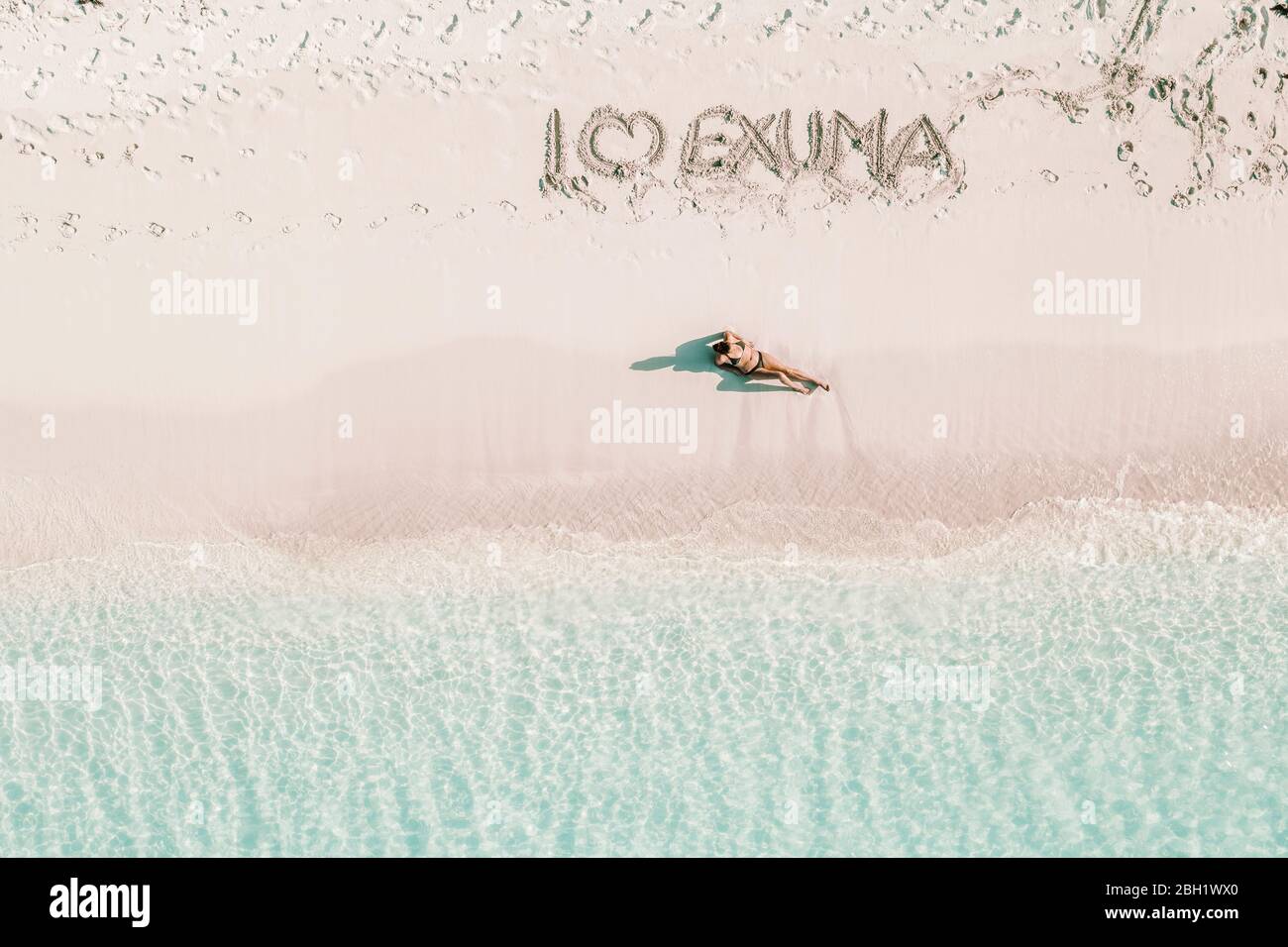 Woman sunbathing under text I love Exuma, Bahamas, Caribbean Stock Photo