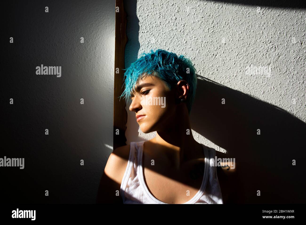 Androgyne young woman with blue hair on the balcony Stock Photo