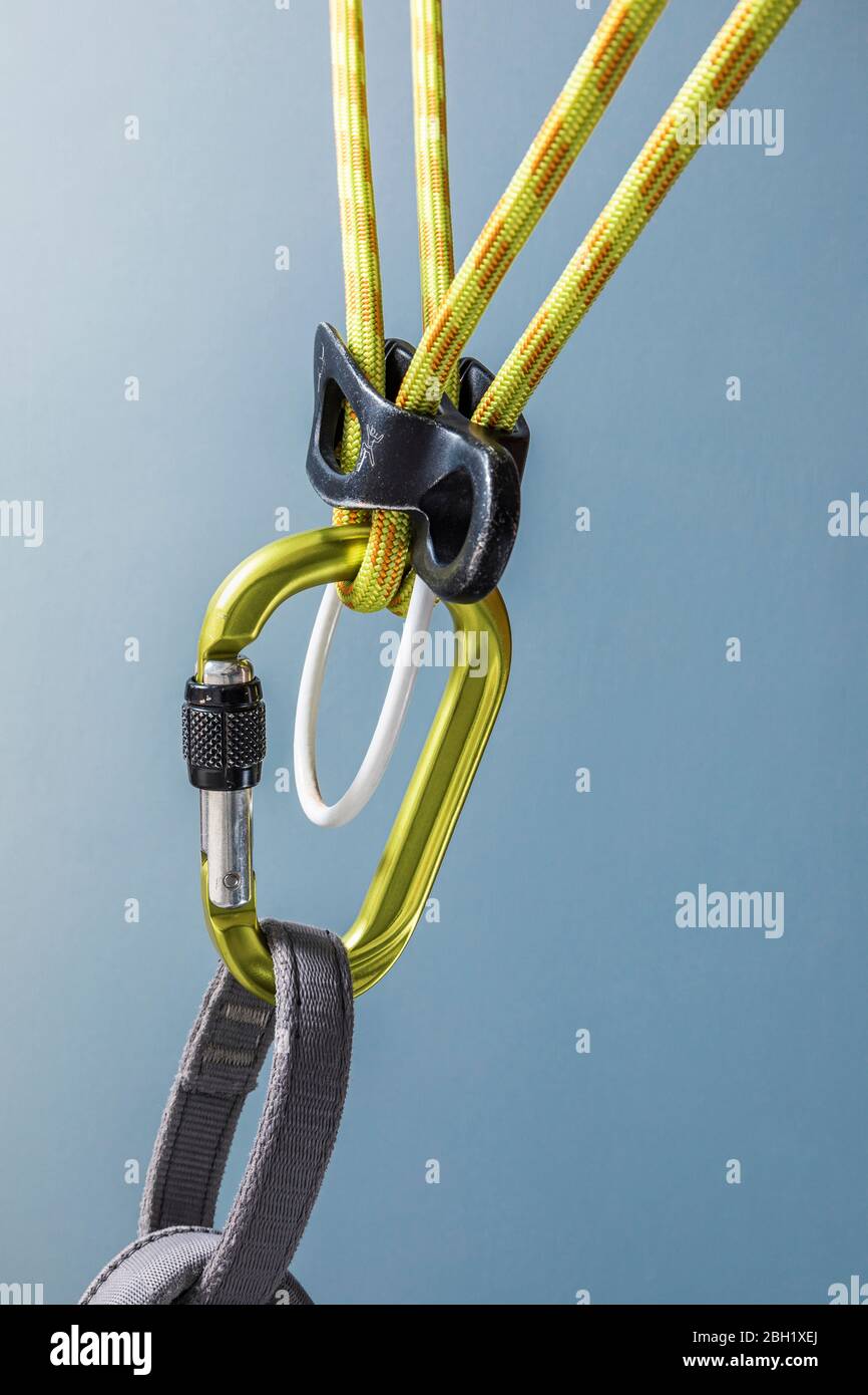 Climbing carabiner on harness loop and rope through descender Stock Photo