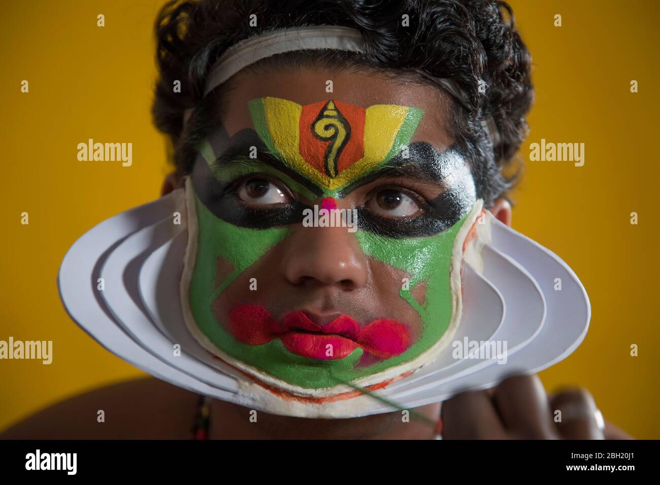 Kathakali dancer giving a touch up on his face. Stock Photo