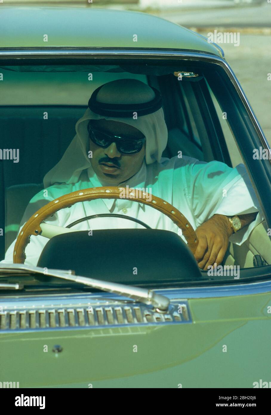 Qatar, People, Man wearing sunglasses sat behind wheel of car. Stock Photo