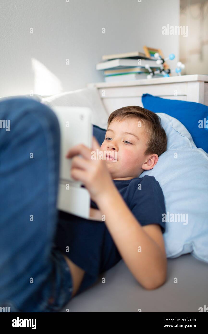 Boy using his tablet during the corona crisis at home Stock Photo
