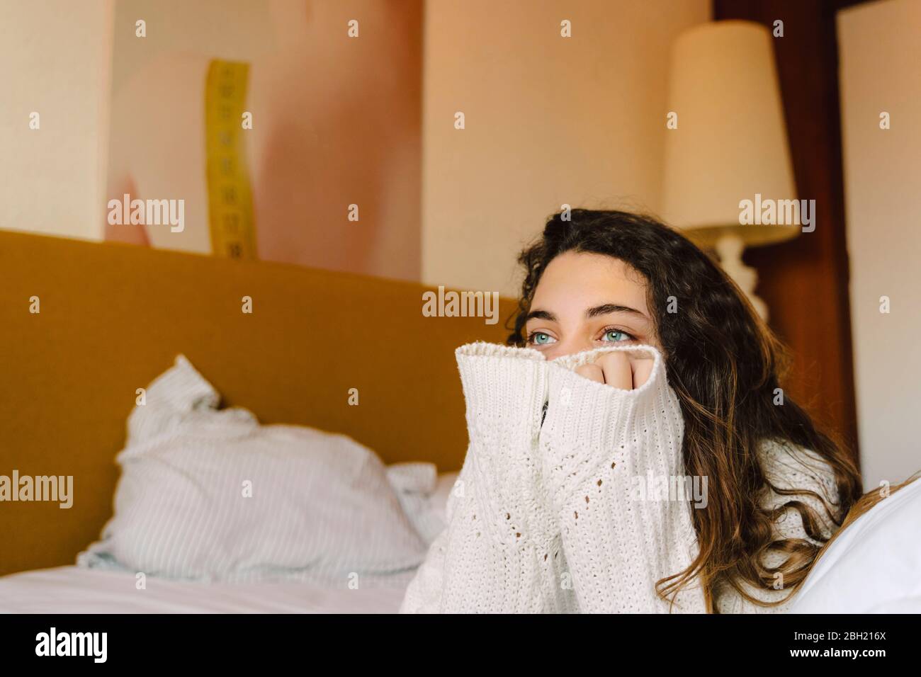 Portrait of girl on bed looking at distance Stock Photo