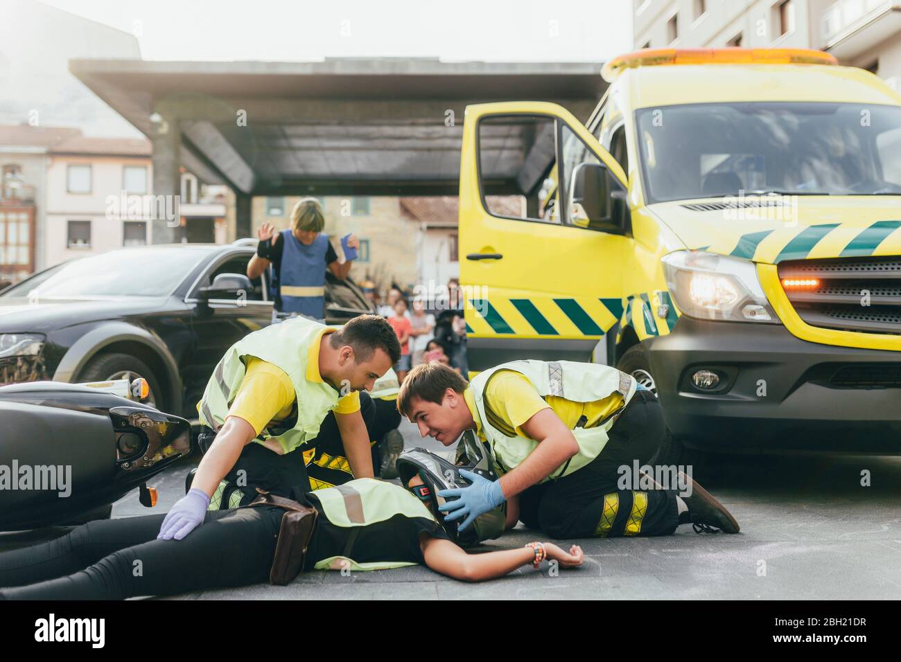 Paramedics helping crash victim after scooter accident Stock Photo