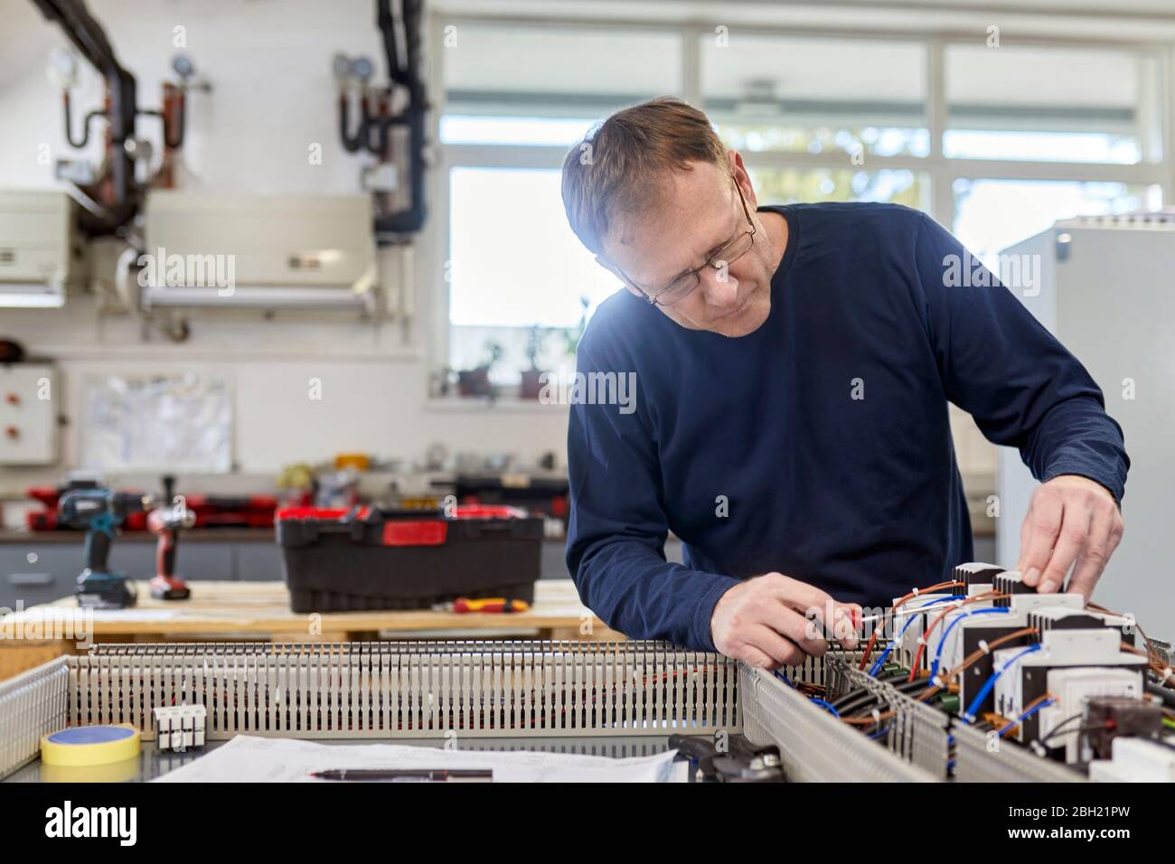 Electrician working on circuitry in workshop Stock Photo