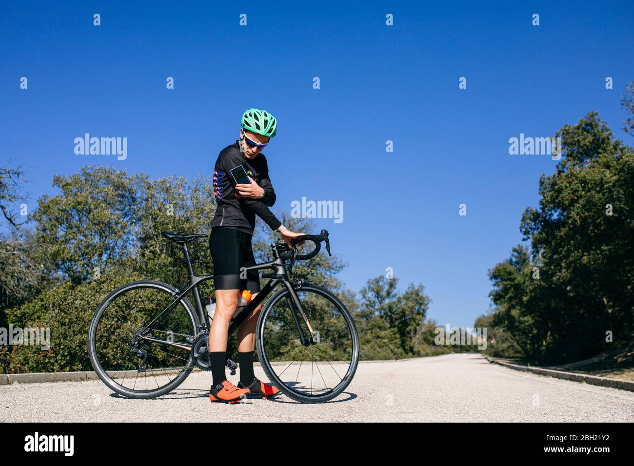 Diabetic cyclist checking his sugar level during a break on country road Stock Photo