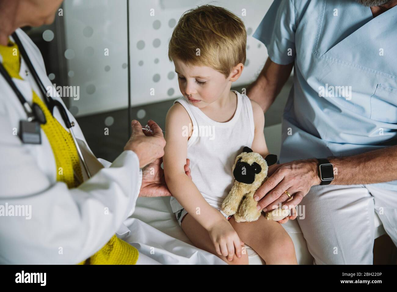 Pediatrist injecting vaccine into arm of toddler Stock Photo