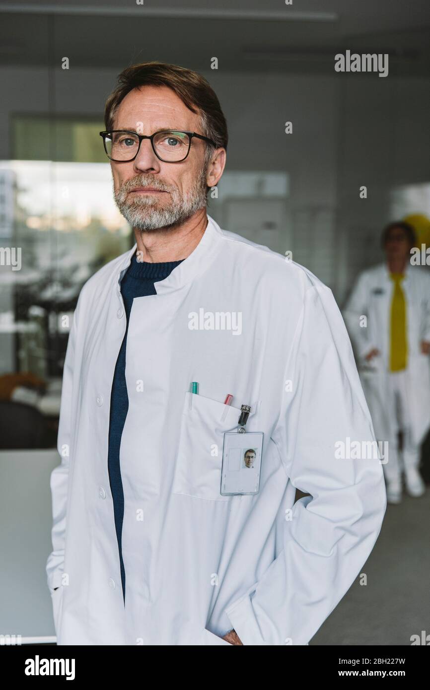 Serious mature doctor standing hi-res stock photography and images - Alamy