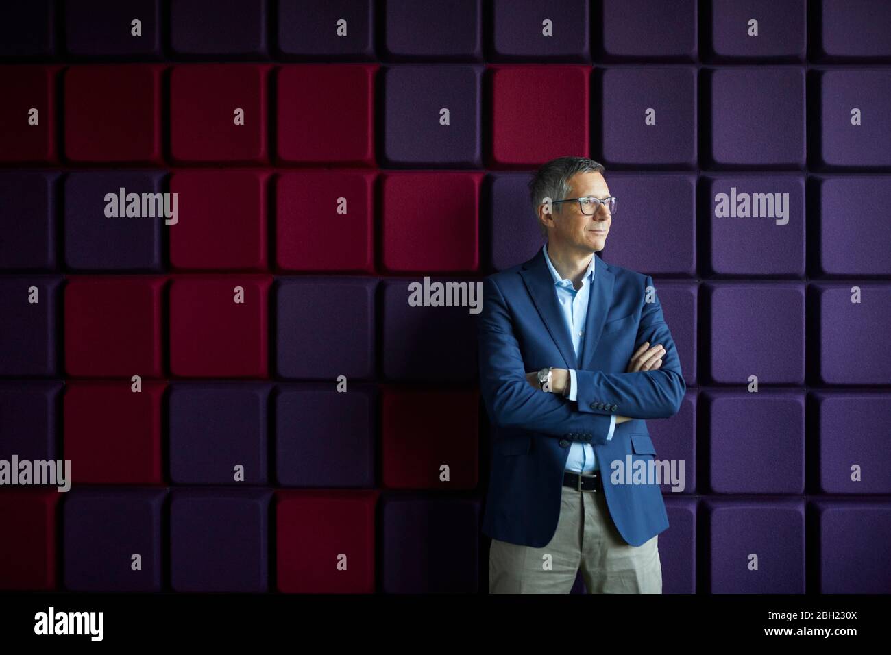 Businessman standing at a noise reduction wall in office Stock Photo