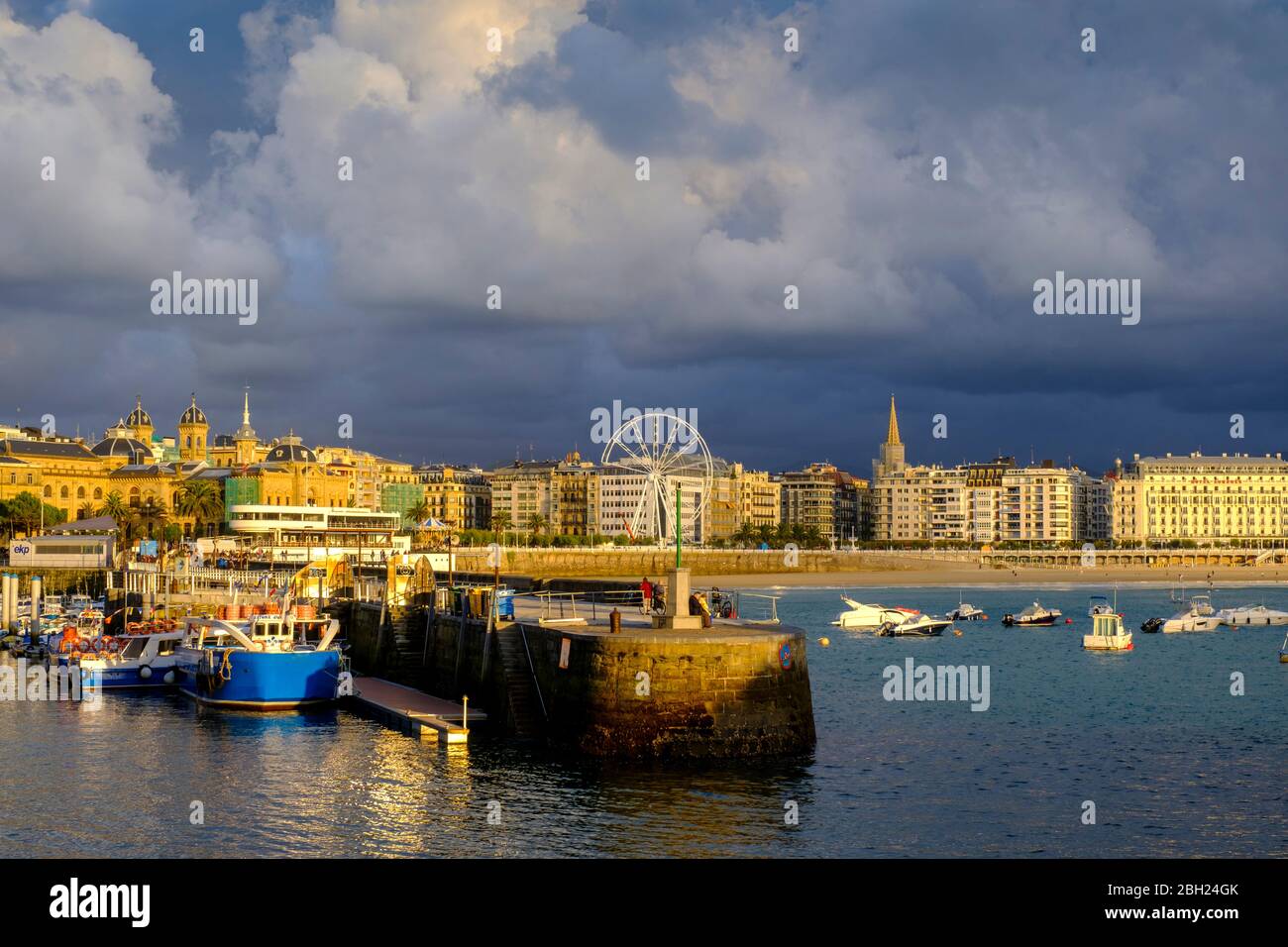 Spain, Gipuzkoa, San Sebastian, Storm clouds over harbor of coastal town Stock Photo
