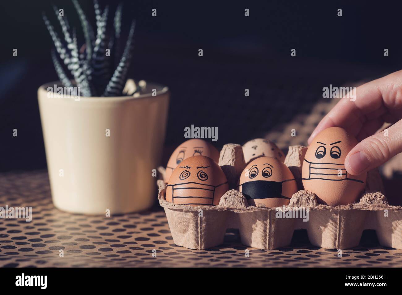 Easter eggs with face masks in a cardboard box Stock Photo