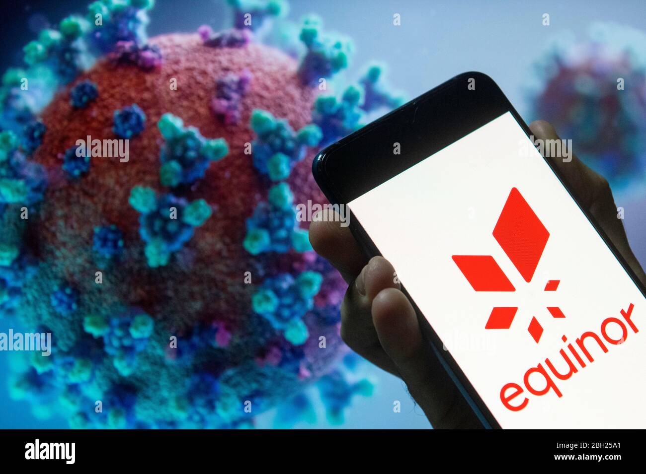 In This Photo Illustration A Norwegian Multinational Energy Company Equinor Asa Logo Seen Displayed On A Smartphone With A Covid 19 Coronavirus Image In The Background Stock Photo Alamy