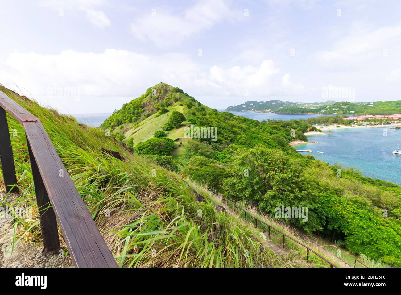 Scenic panoramic tropical landscape from a concrete path guarded by a wooden railing Stock Photo