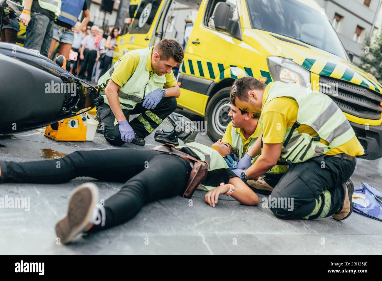 Paramedics helping crash victim after scooter accident Stock Photo
