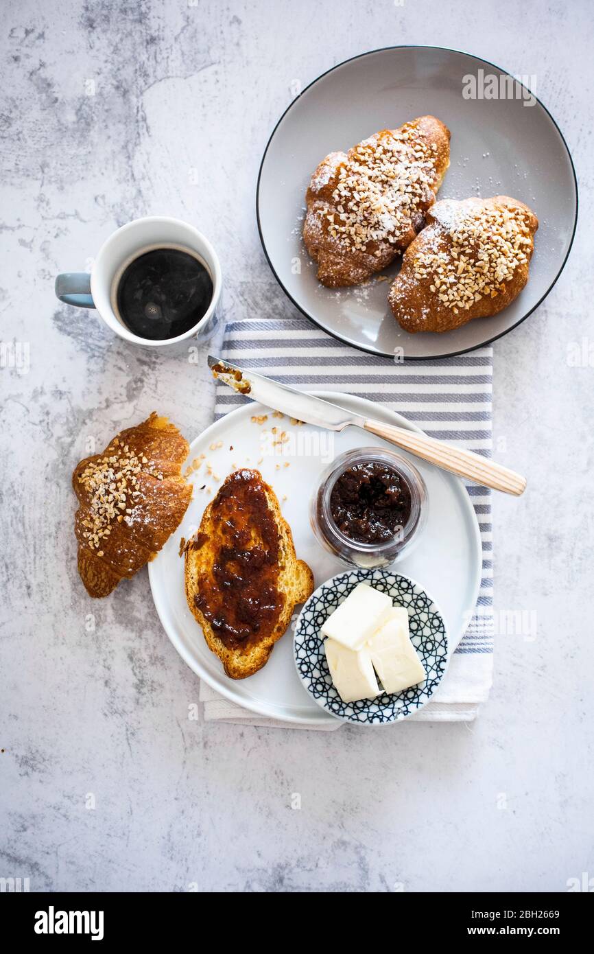 Cup of coffee, butter and brioche with berry jam Stock Photo