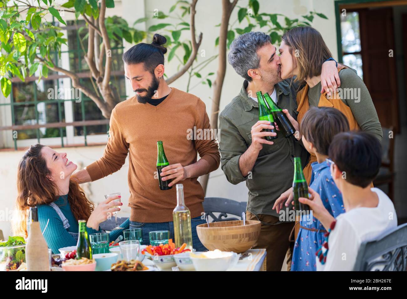 Happy friends enjoying lunch in the countryside, drinking wine and beer Stock Photo