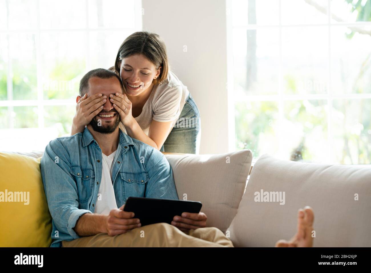 Young couple at home having fun on couch Stock Photo