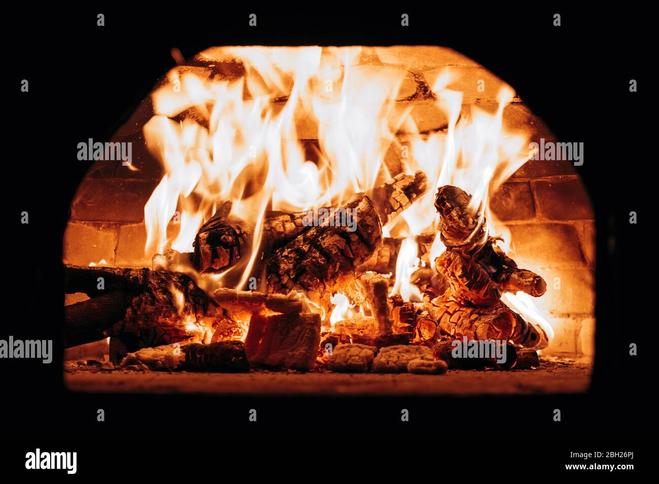 Firewood burning in pizza oven Stock Photo