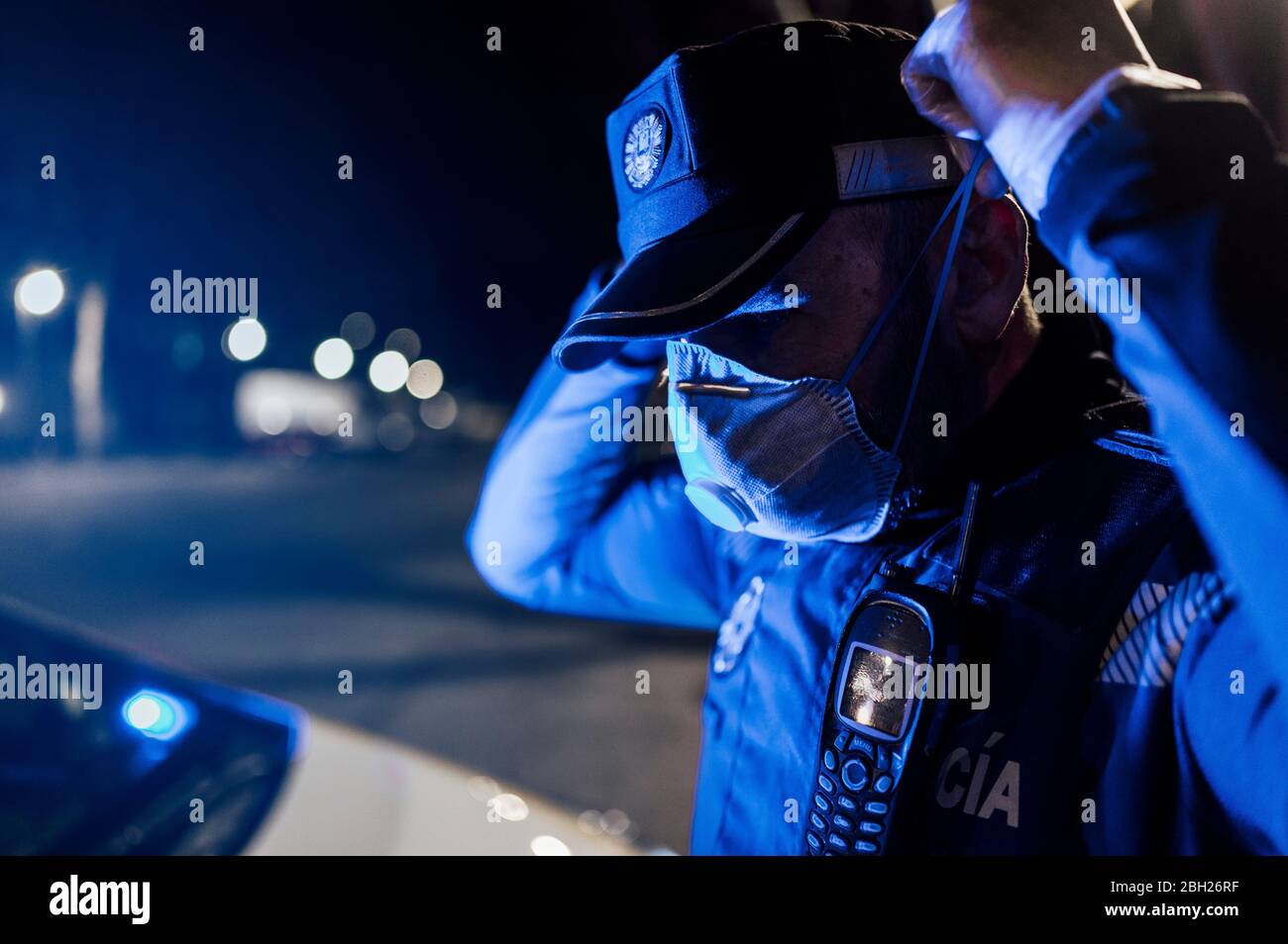Portrait of policeman wearing mask and protective gloves at night Stock Photo
