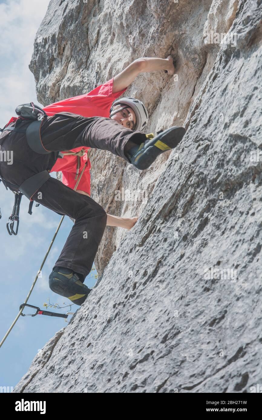 Mountain climber climbing rock face Stock Photo