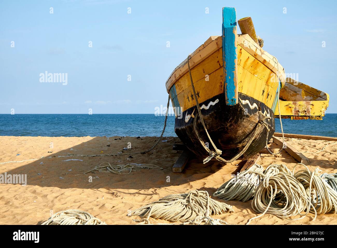 Ghana, Keta, Old fishing boat left on sandy coastal beach Stock Photo