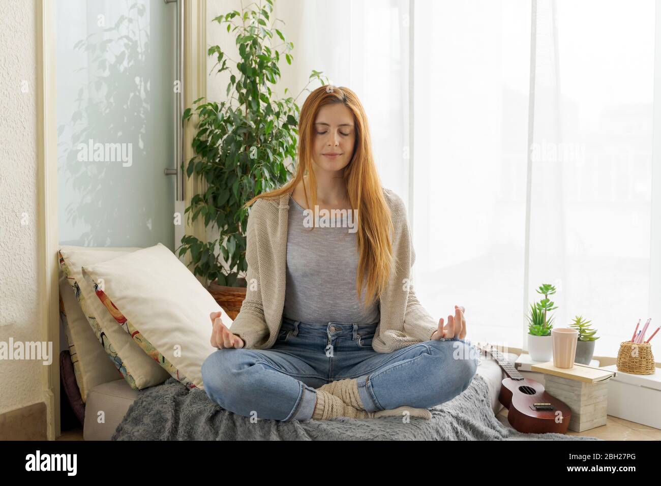 Young woman practicing yoga at home Stock Photo