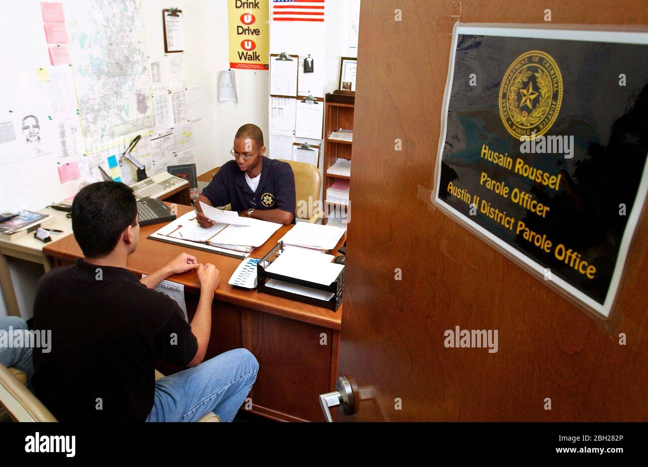 Austin, Texas USA, September 5, 2003:  African-American parole officer meets with parolee to discuss monitoring. MR  ©Bob Daemmrich Stock Photo